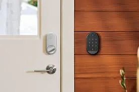 Close-up of a smart lock and keypad, part of comprehensive Smart Home Solutions, mounted on a white door and wooden wall, respectively.